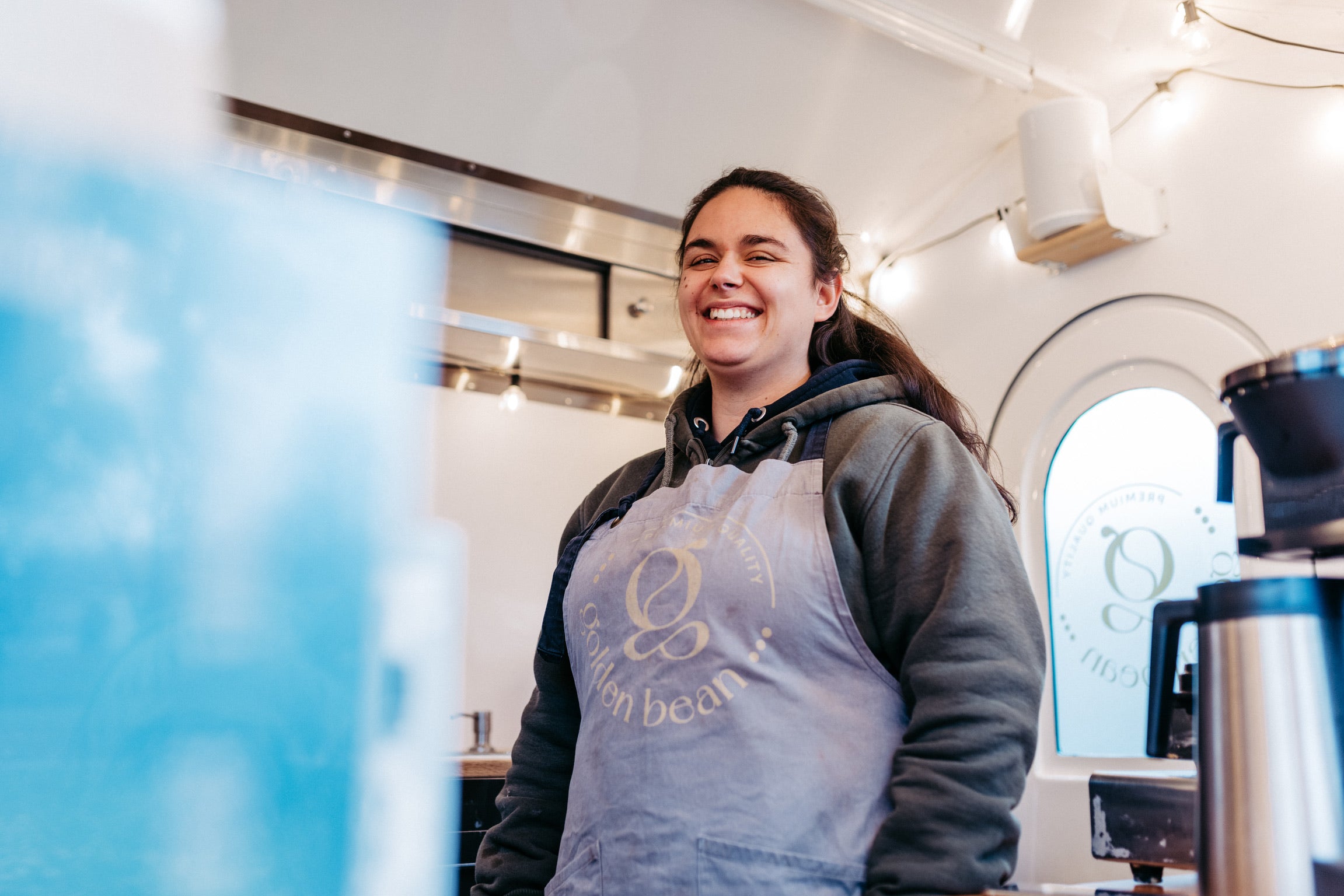 Barista von Golden Bean bereitet Kaffee in einem mobilen Kaffeewagen zu.