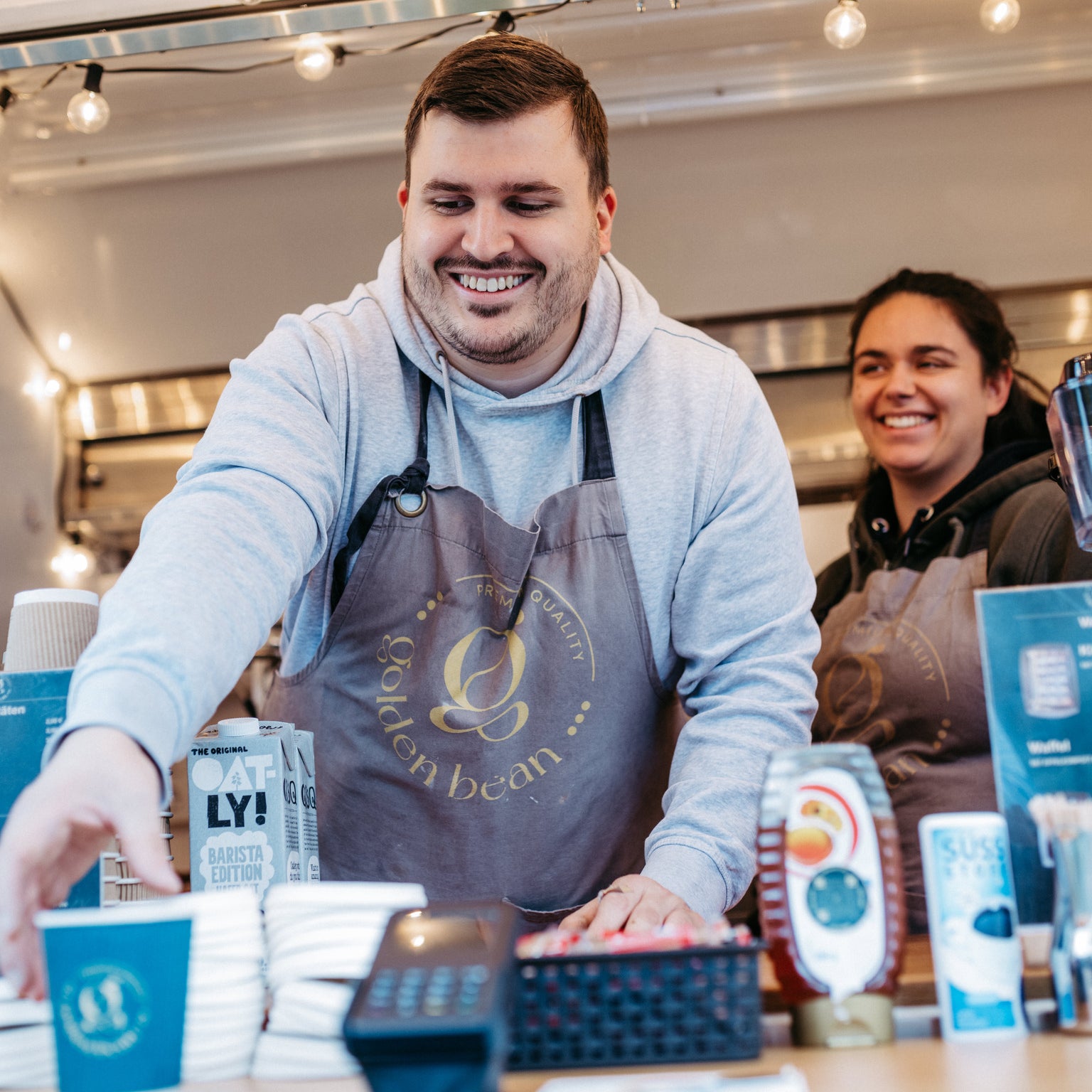 Golden Bean Barista serviert Kaffee aus einem Kaffeewagen.